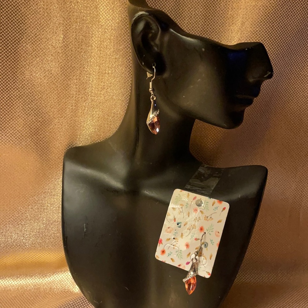 Silver colored pink teardrop earrings on fish hooks.